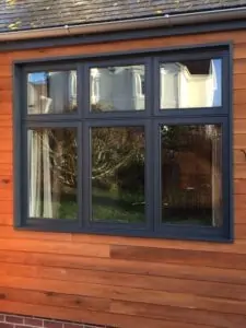 grey casement window on wood facade