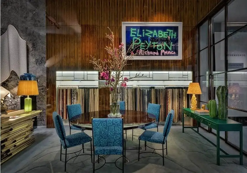 a beautiful living room with blue chairs round table and stylish wall design