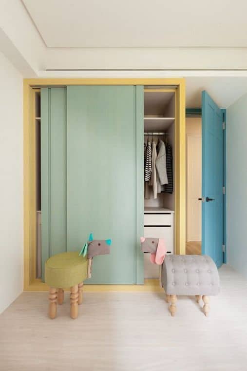 pastel green and yellow closet with white floor and ceiling and blue door