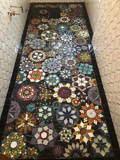 Multi-coloured flower pattern of mosaic tile on black floor