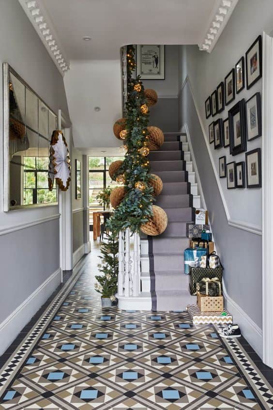 white, black, and blue mosaic flooring tiles in geometrical arrangement for entrance hallway with white and grey staircase