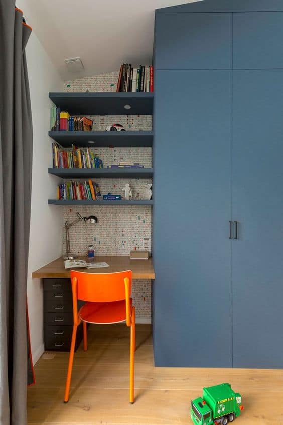 Blue wardrobe with left side study table set up and vibrant orange chair