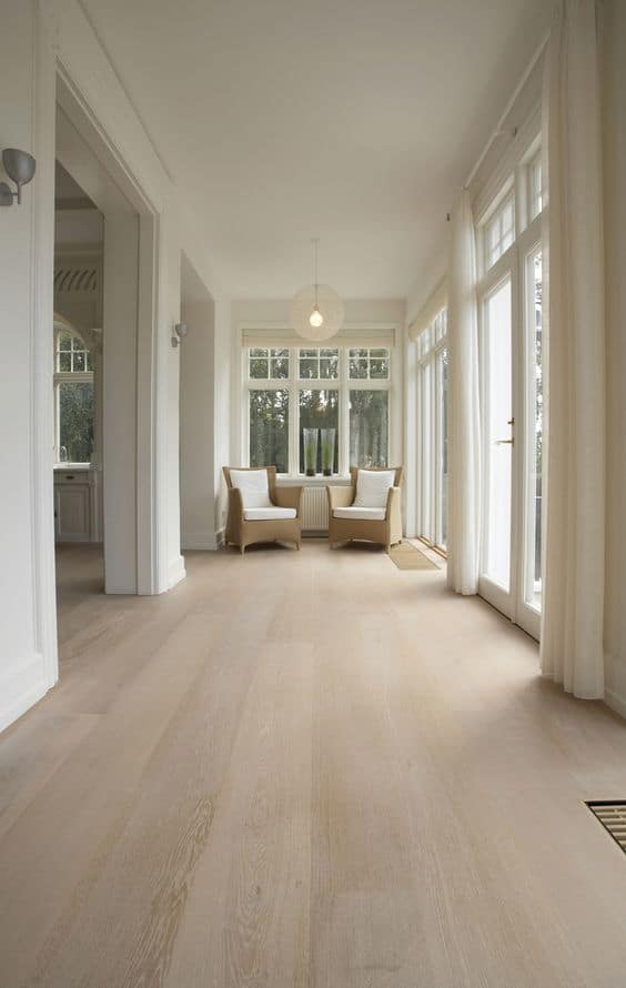 light coloured vinyl tiles for floor with off-white curtains, white walls, and neutral shade sofas. 