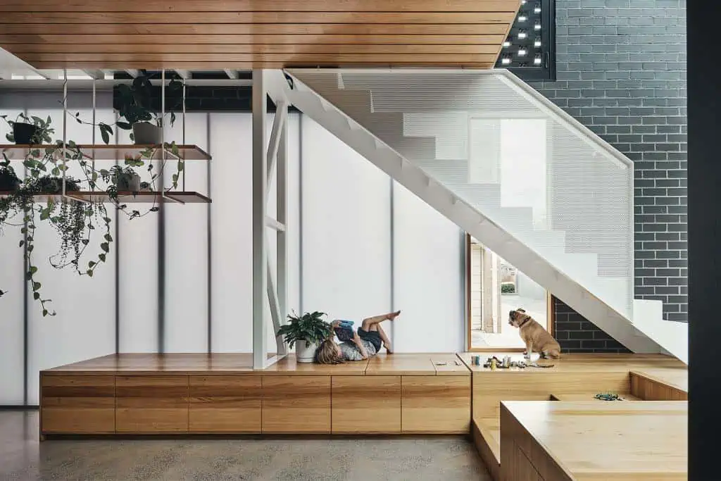 modern staircase beside black brick wall, home design interior with wooden ceiling and a wood seating deck