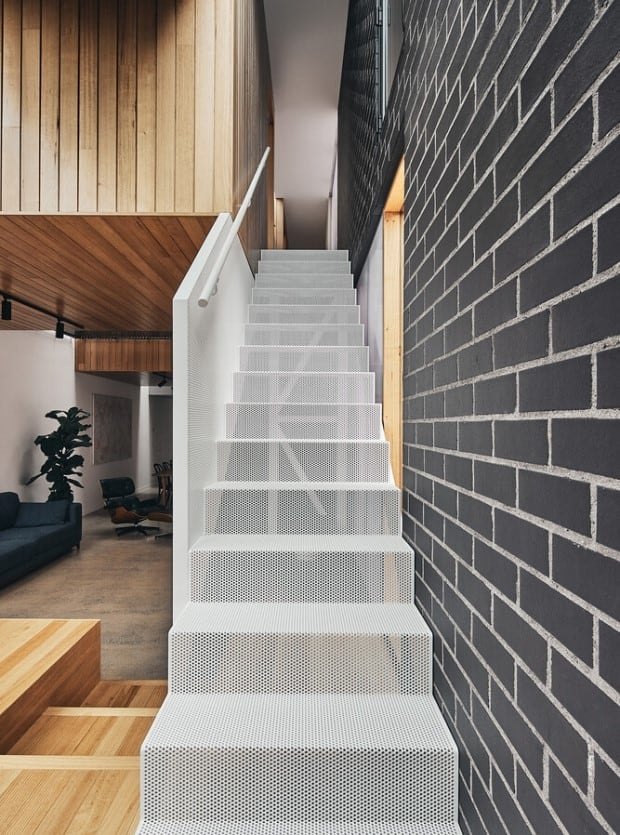 modern staircase beside black brick wall, home design interior with wooden ceiling and a wood seating deck