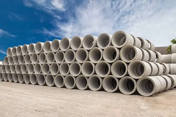  Stack of concrete drainage pipes for wells and water discharges with blue sky