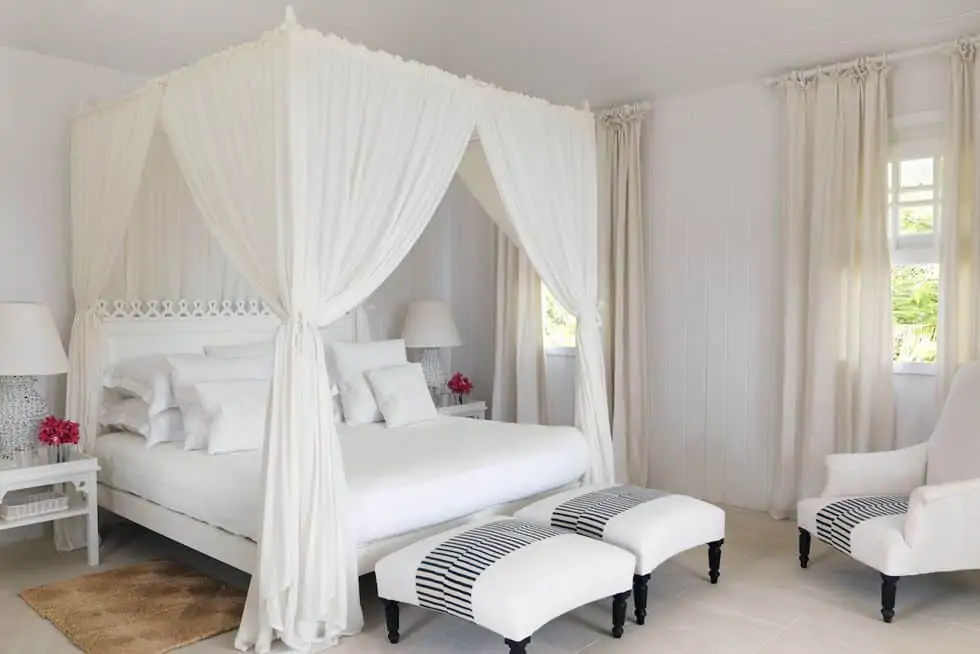  master bedroom with white canopyand sheer curtains