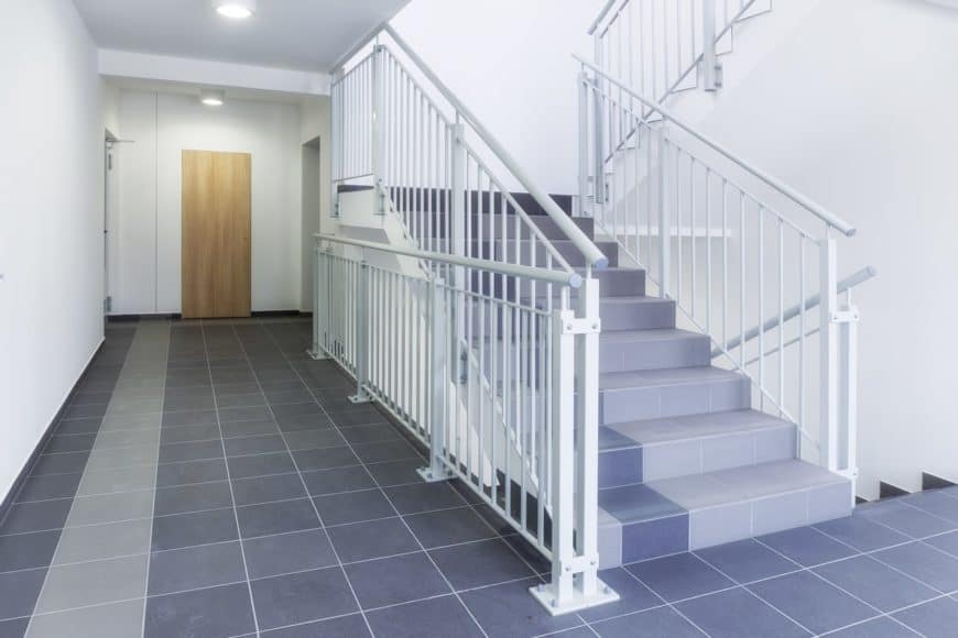 staircase with purple tiles flooring and white railings matching the white walls