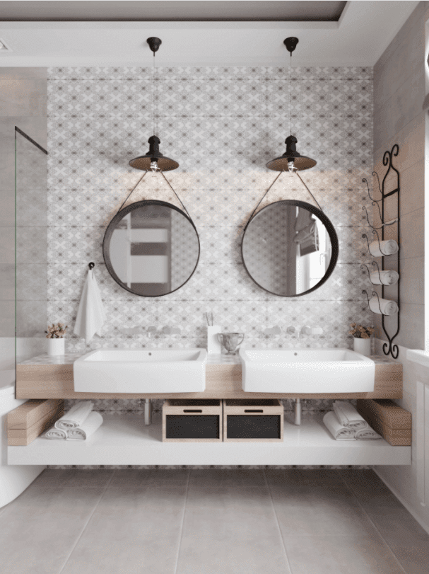 Two round bathroom mirrors hanging on a wall, pattern bathroom tiles, table top washbasins