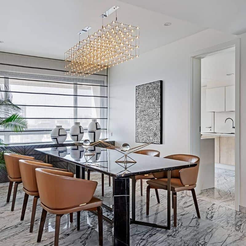 dining woom with black table brown chairs and chandelier