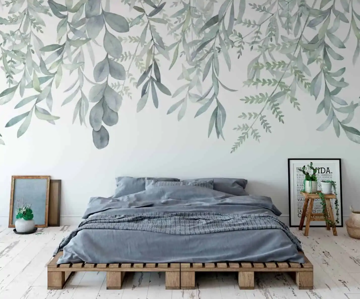 bedroom with white wooden flooring and picture frames on the floor.