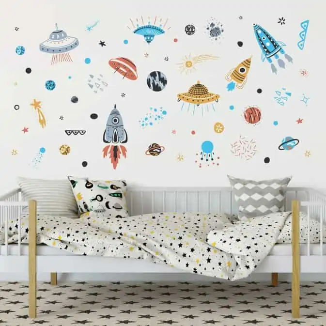 kids room with a small bed and space inspired decal