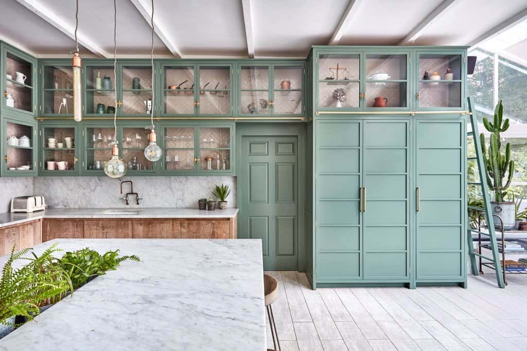 modern kitchen with green cabinetry; kitchen cupboards tiled in pink