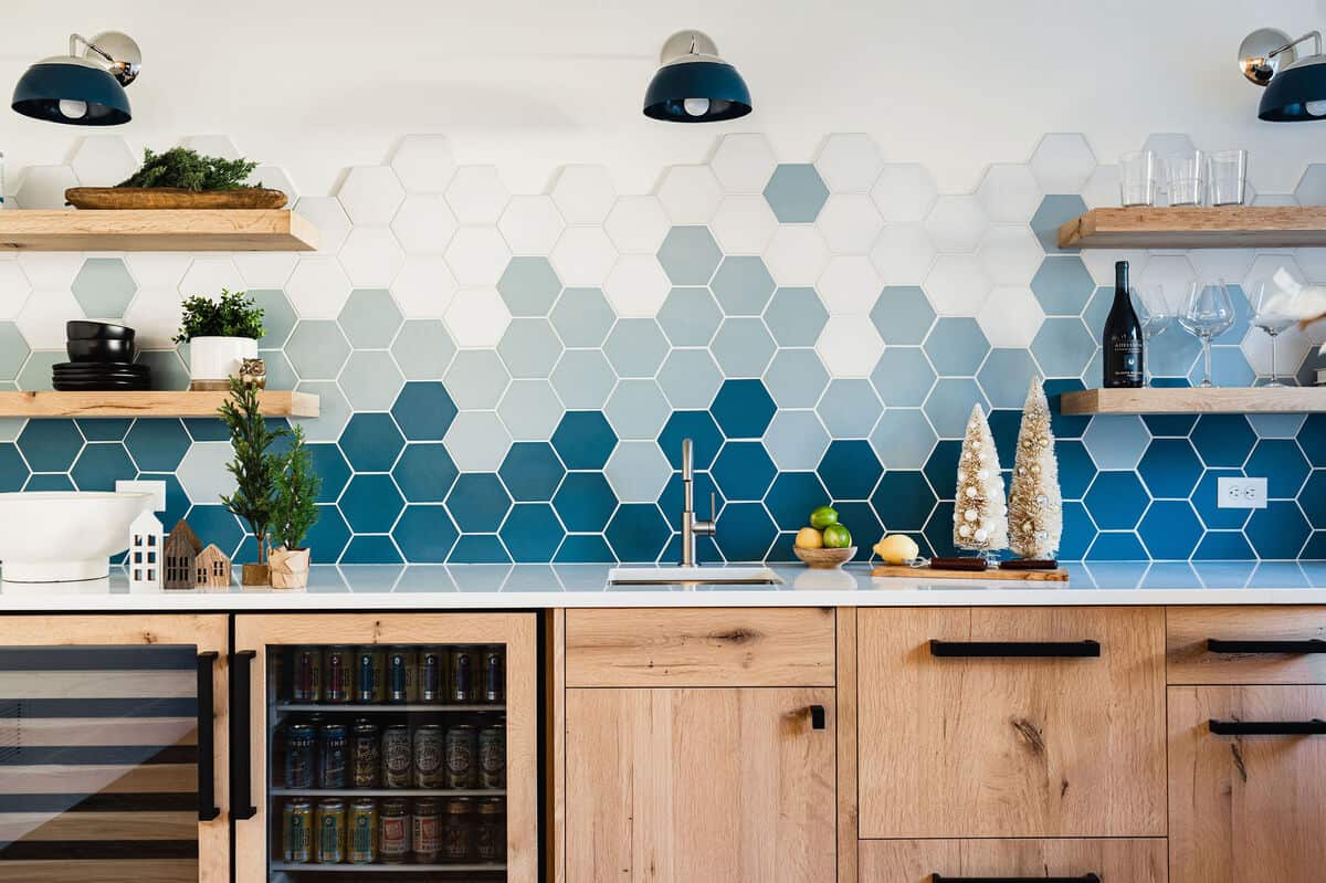 blue and white coloured hexagonal backsplash with wooden shelves and cabinetry