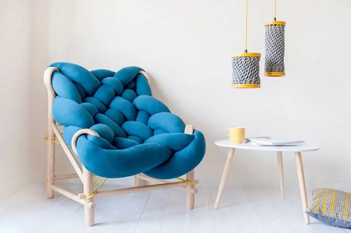 Noodle design furniture in blue color placed in a living room with wooden furniture and white wooden floors.
