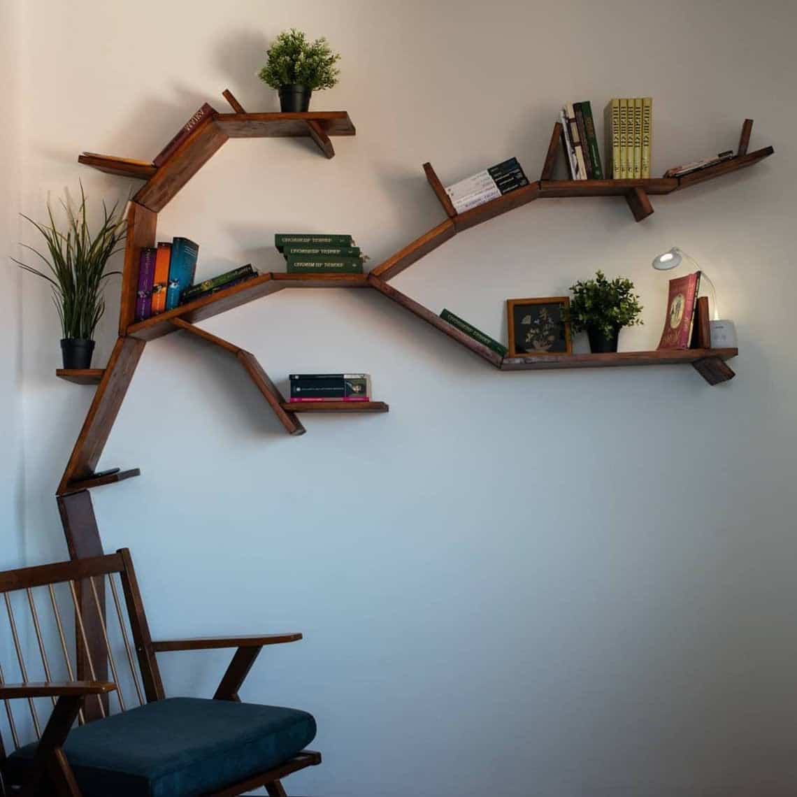 dark brown tree shaped bookshelf, chair, table