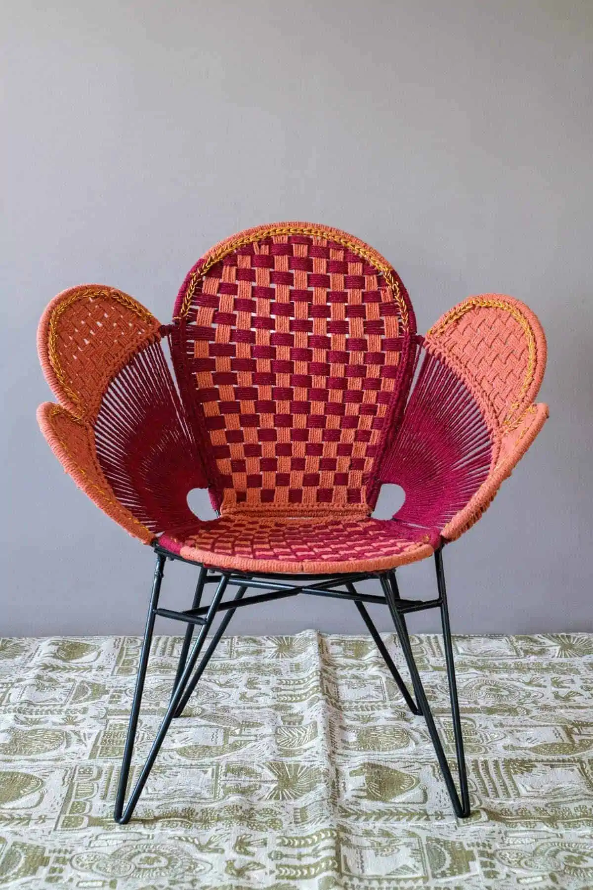 Multicolored rattan chair with metal legs and an eccentric butterfly design