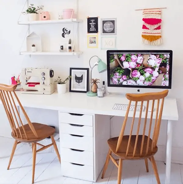 white computer table with drawers, two wooden chairs, decorated room