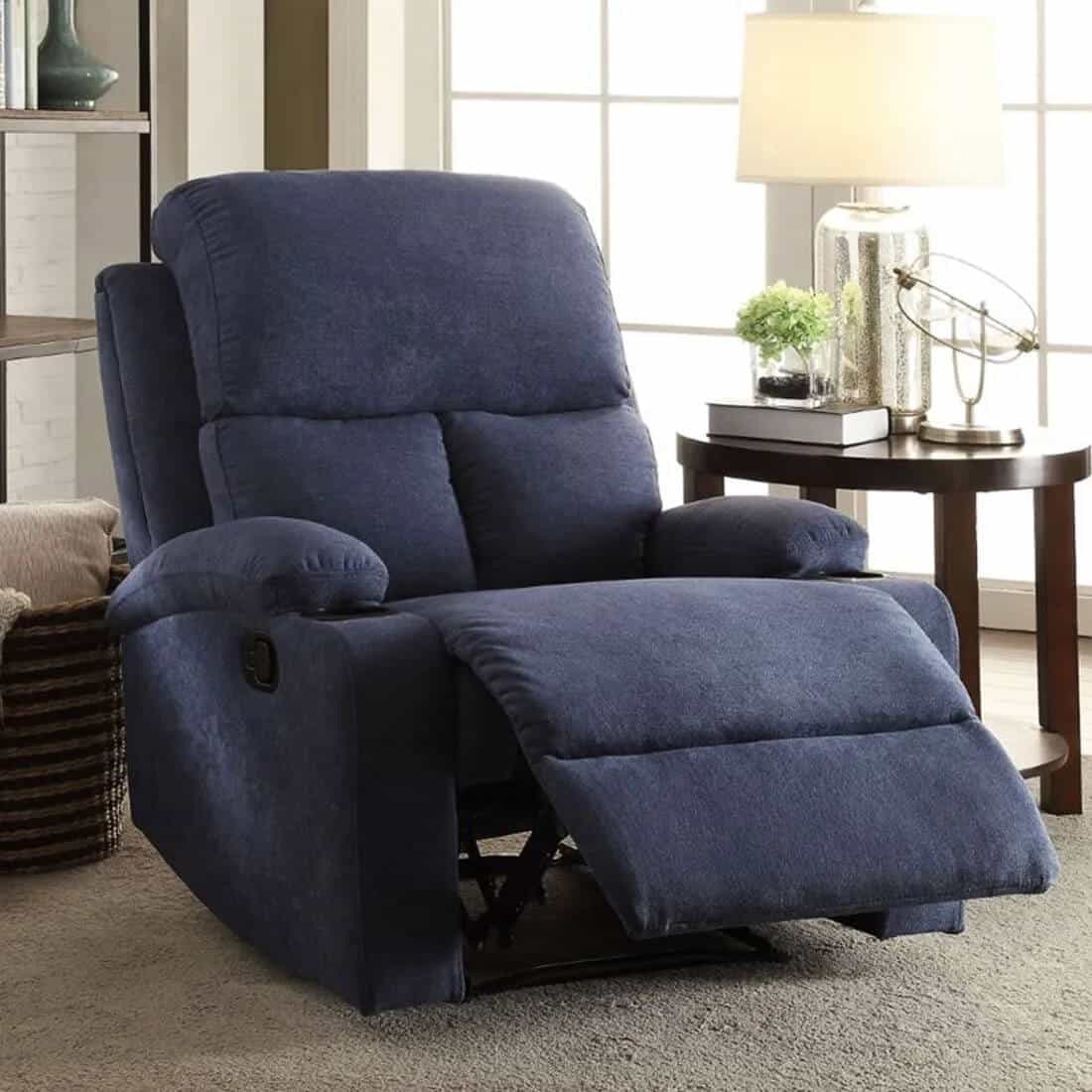 blue recliner in a home setting with a brown side stand, lamp and a house plant