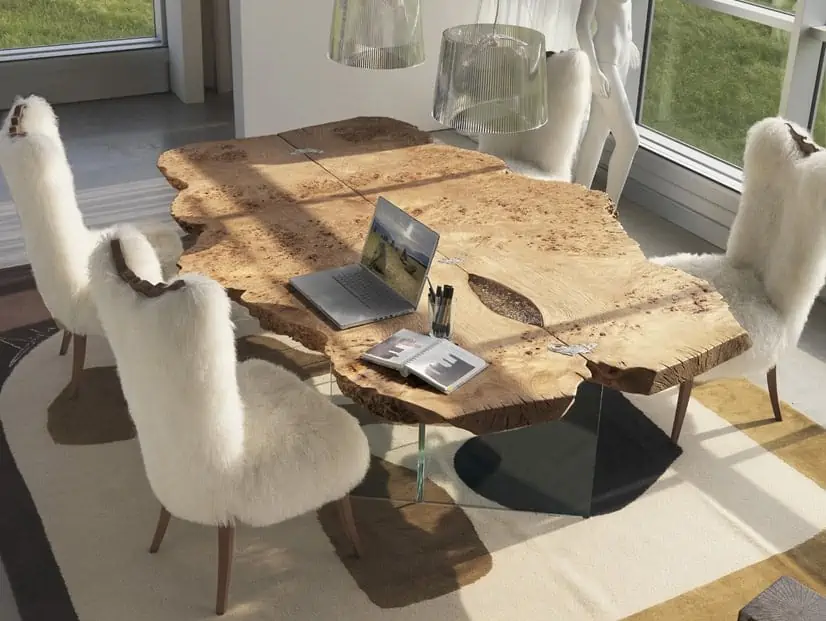 Freeform wooden dining table with 4 chairs covered in white fur seatings, with wooden legs in a well lit room