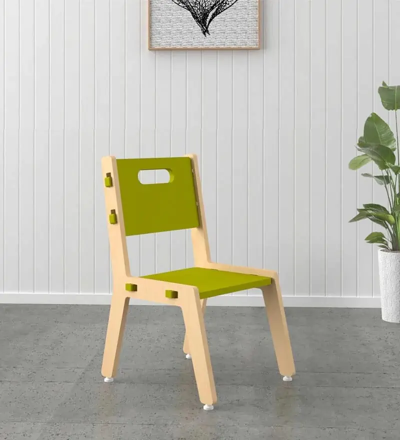 green colored kids plastic chair placed in a home setting with a potted flower and a wall painting.