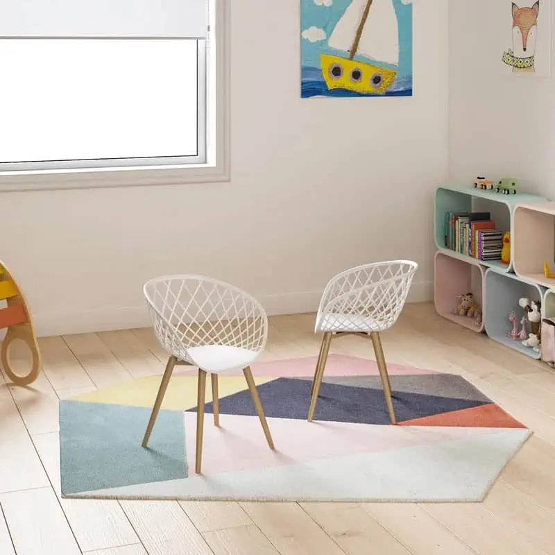 kids room with patterned rug, bookshelf and wall painting.