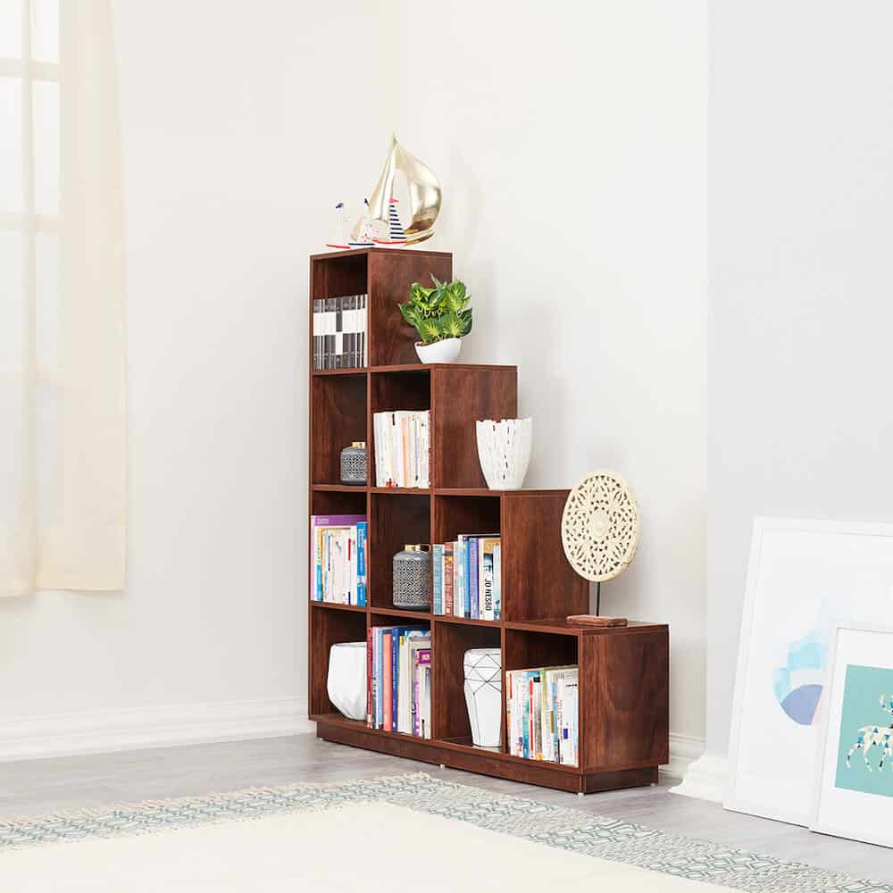 brown wooden stair shaped bookcase, plants, articles