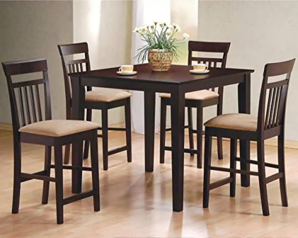 Dark brown wooden square dining table with 4 dark brown wooden chairs, with light orange cushions in a room