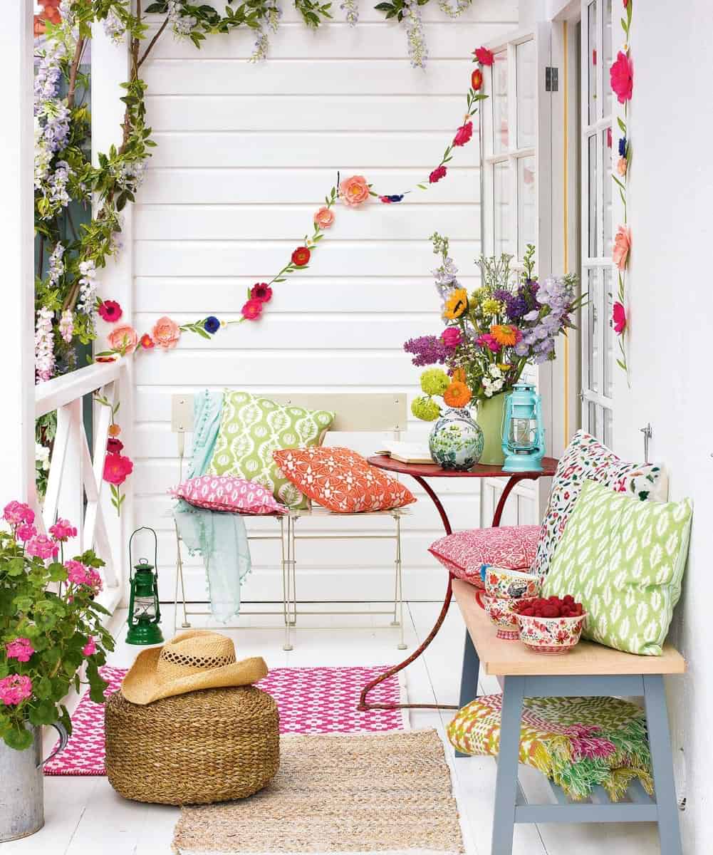 Stunning balcony decoration ideas with flower and colourful pillows in white, green and pink
