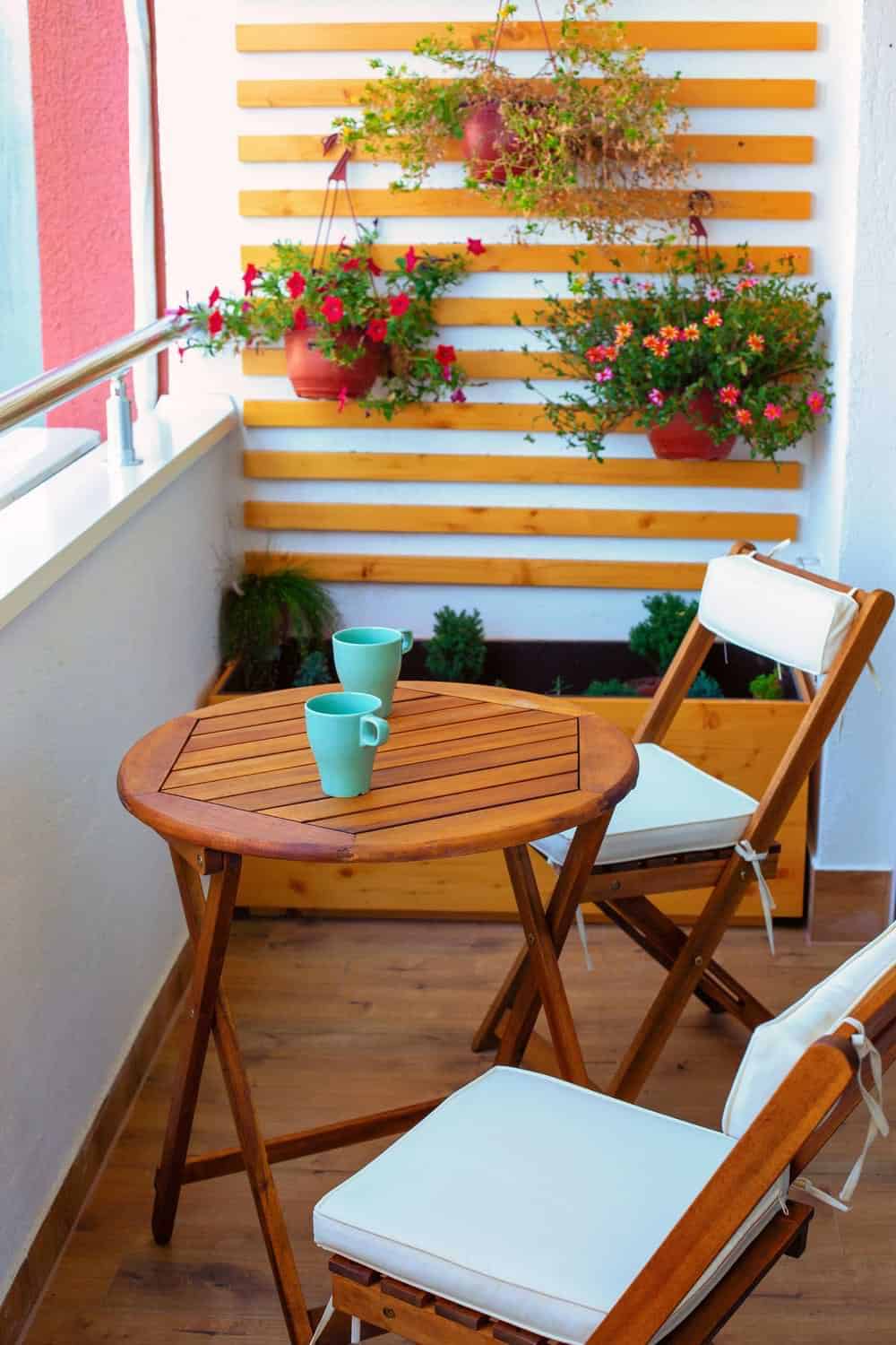 Brown wooden floor balcony with chairs and table