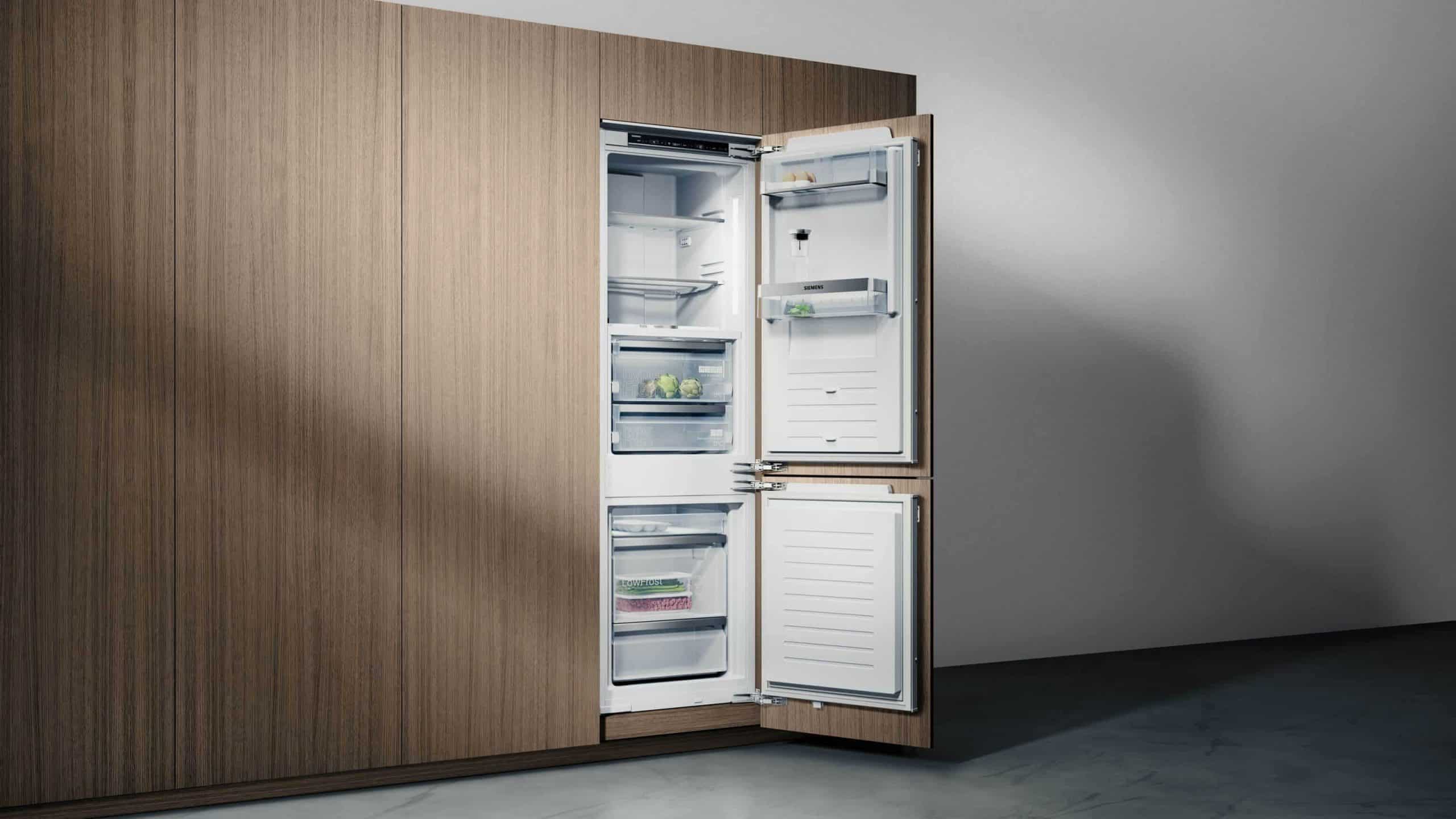 built-in bottom-freezer fridge flushed into brown cabinetry, built in appliances for kitchen, premium modern kitchen appliances