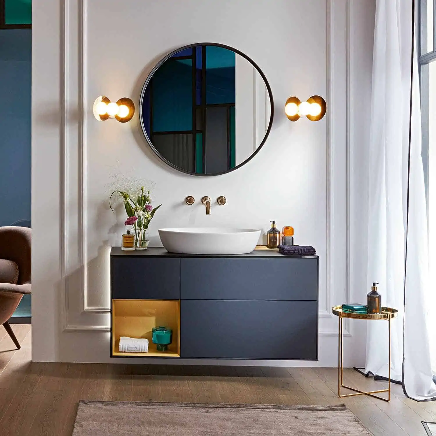 round mirror with a blue cabinet in a bathroom with washbasin design with cabinet and a mirror in hall