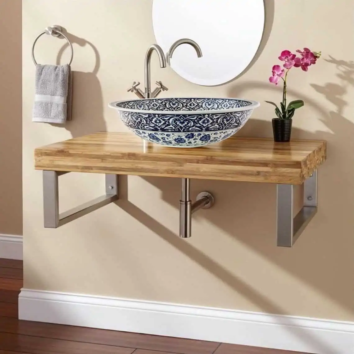 washbasin with a mirror, tap, towel, plant on a brown wooden counter
