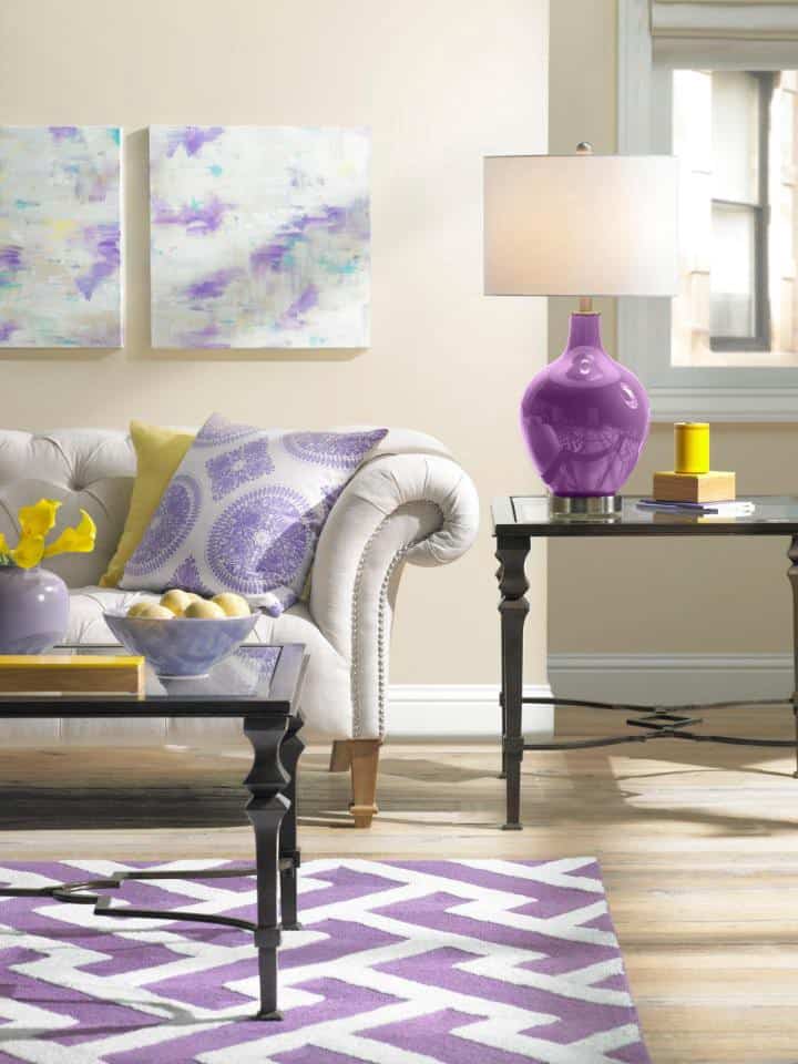 Cream, yellow, purple complementary colour scheme of living room with lamp, couch & coffee tables