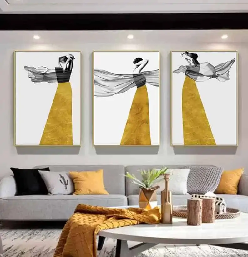 yellow statement paintings in a living room with grey sofa and a table