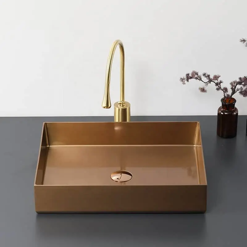 metal sink in bronze and golden colour tap with potted plant