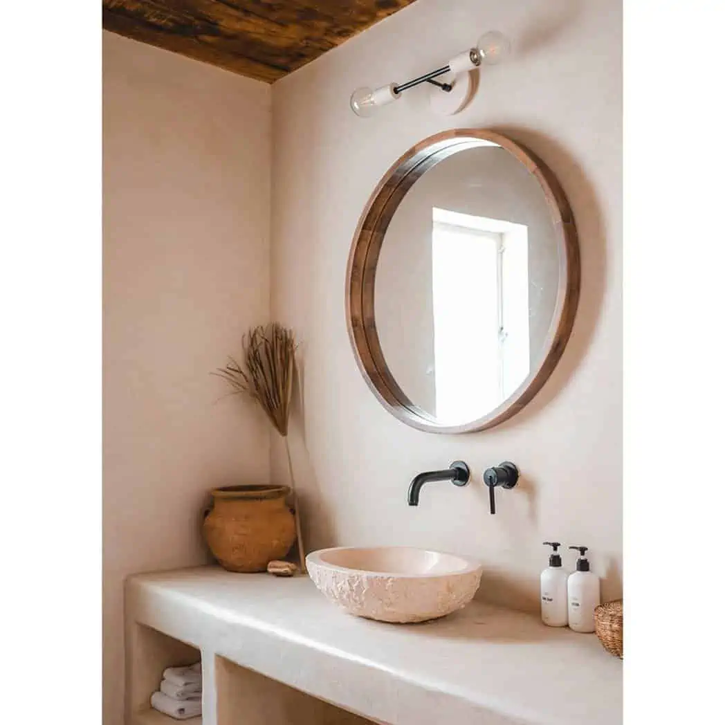 pink washbasin with a mirror, a tap and accessories