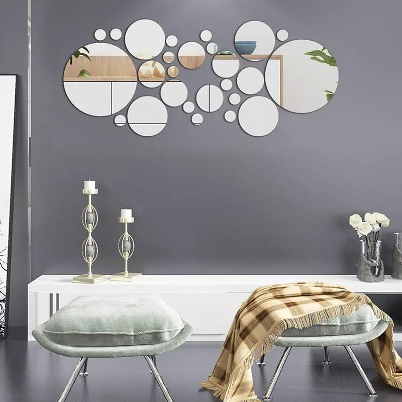 mirror wall décor on a grey wall in a living room with table and chairs