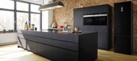 rustic-style modular kitchen with black countertop and built-in kitchen appliances (oven, microwave, refrigerator, hob, and chimney) by Siemens