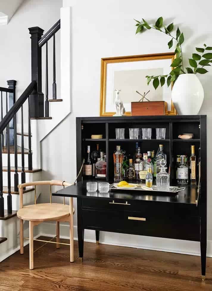 beautiful black wooden cabinet repurposed as liquor table