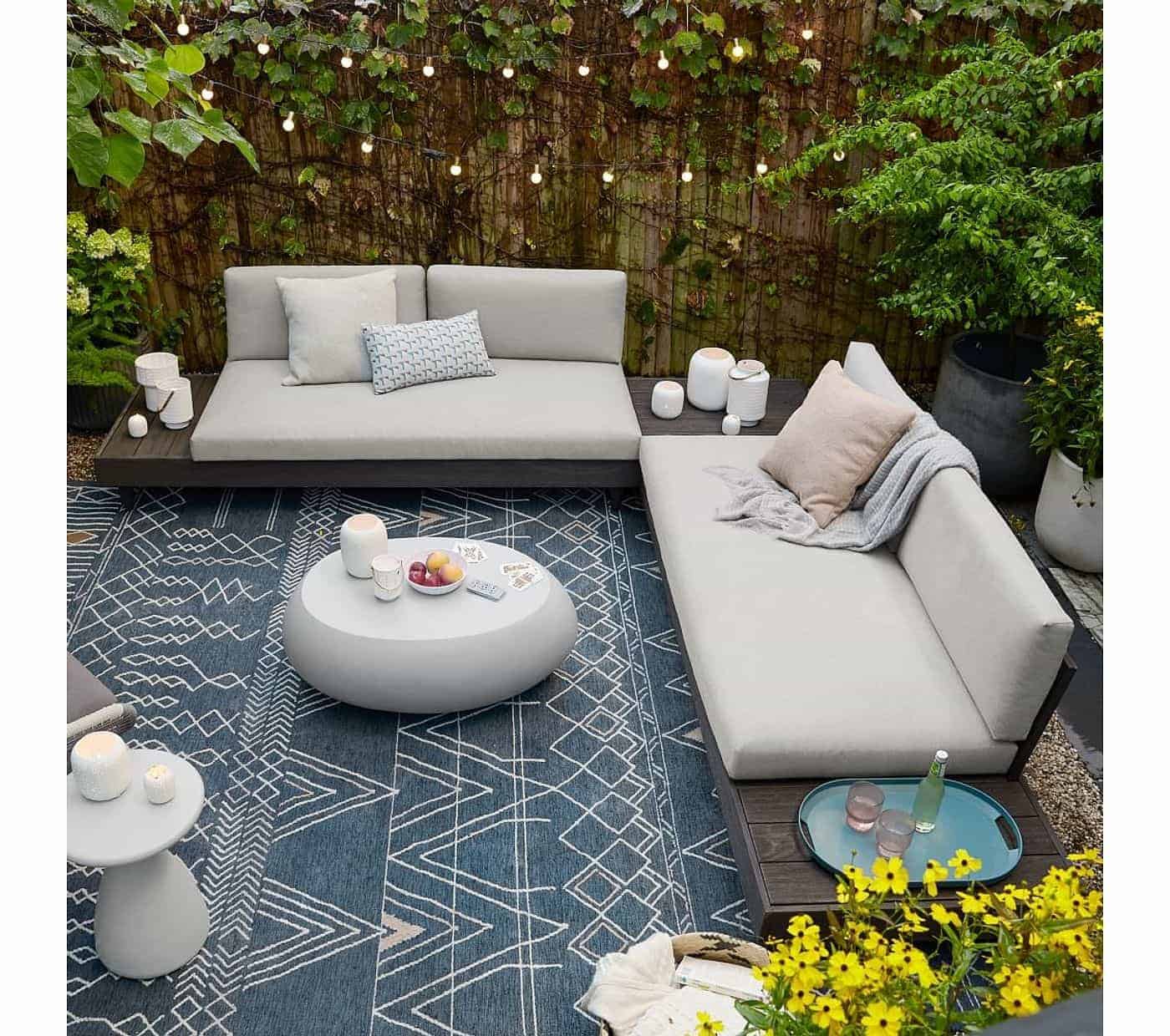 blue rug placed outdoors with white sofa