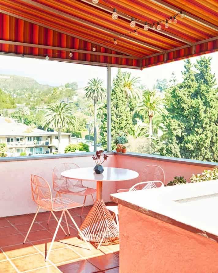 Peach colour balcony with small dining set up