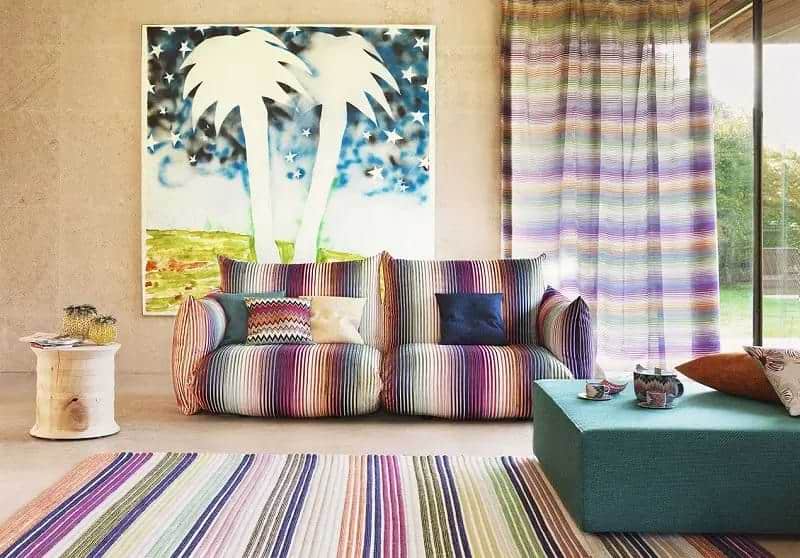Multi colour with pink, green and purple fabric with vertical strips on couch, rug and curtains