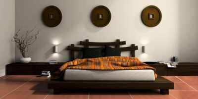 double size bed design photo, off white mattress, black pillows, bedsheet, white walls, lamp, textured floor, brown round wooden wall hangings