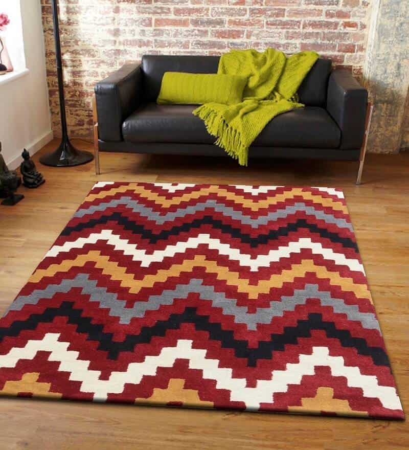 geometric pattern rug in red, white and black colors with a sofa 
