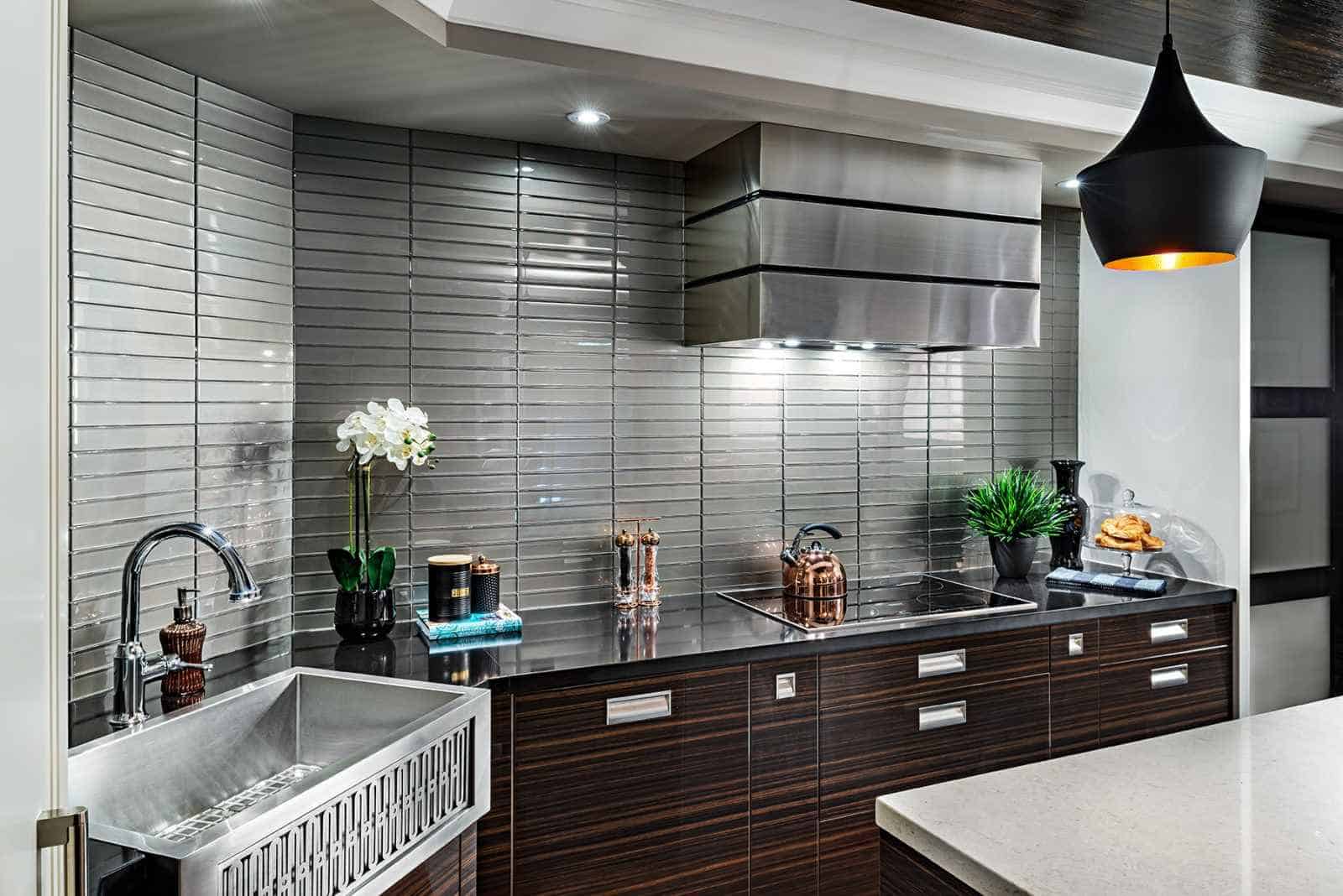 metallic finish silver themed kitchen with brown cabinets and black ceiling lights