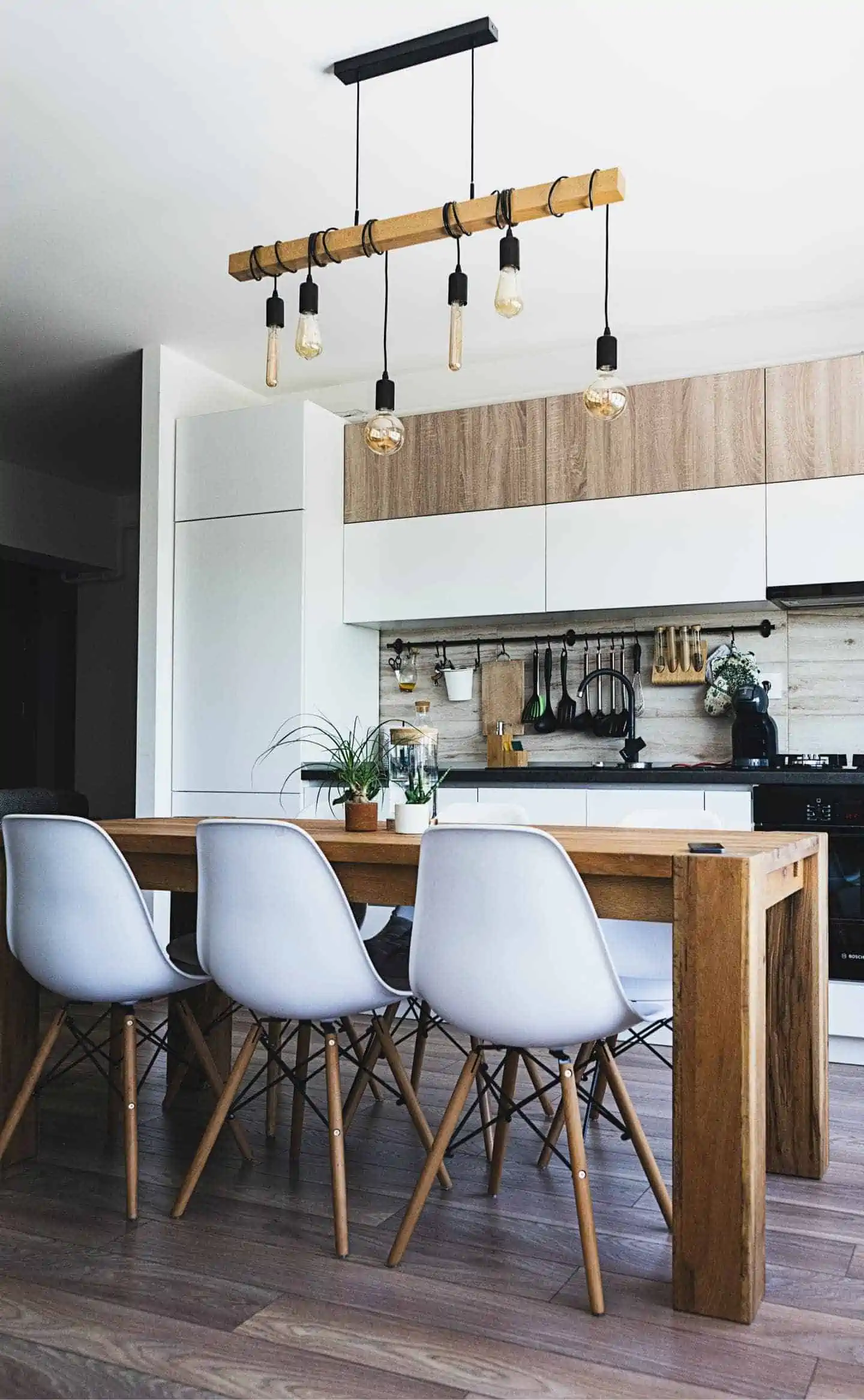 pendant ceiling lights with white chairs and brown wooden table in a kitchen