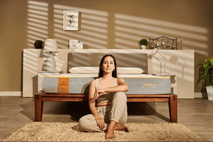 woman sitting in front of bed, decorated bedroom