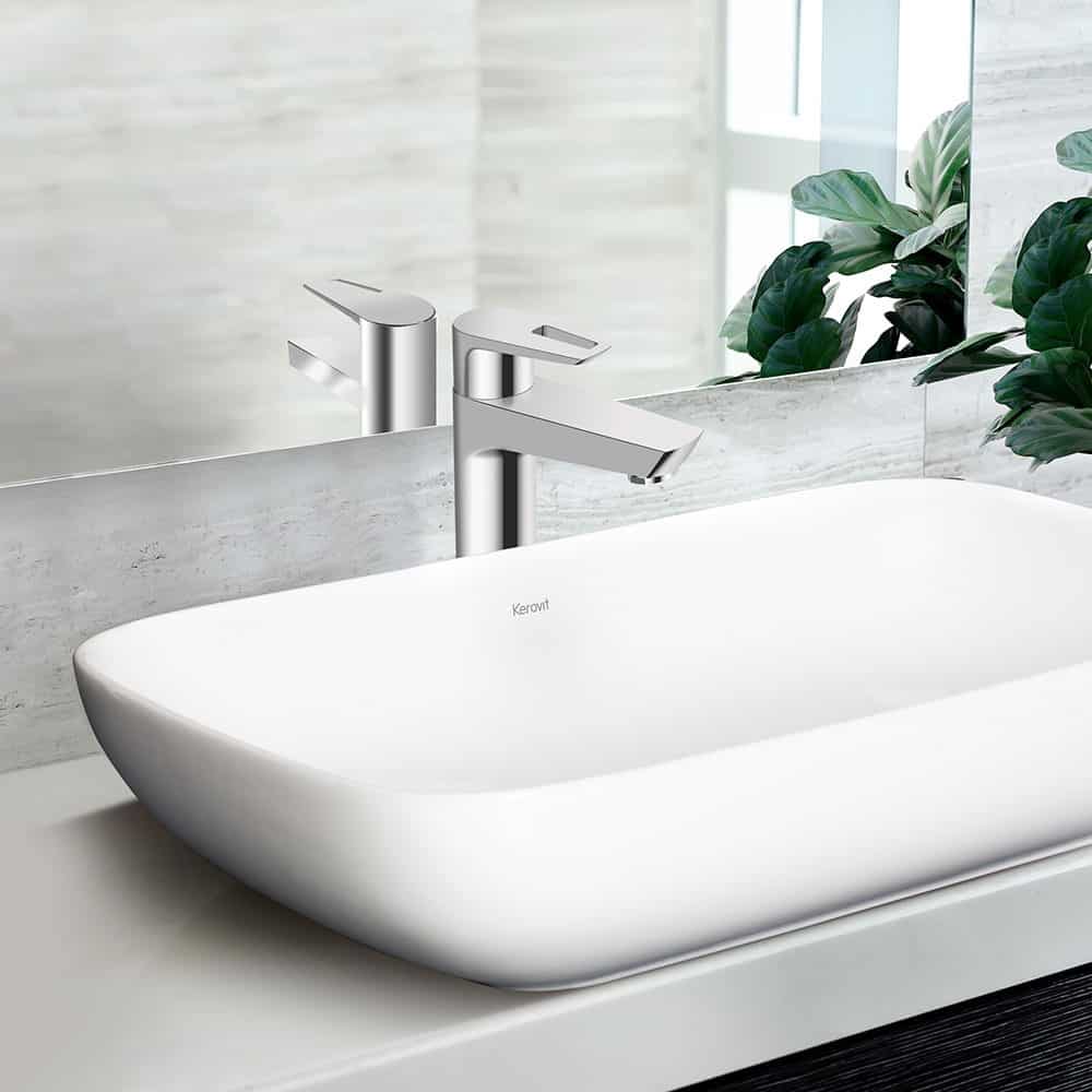 white sink with a mirror and indoor plant