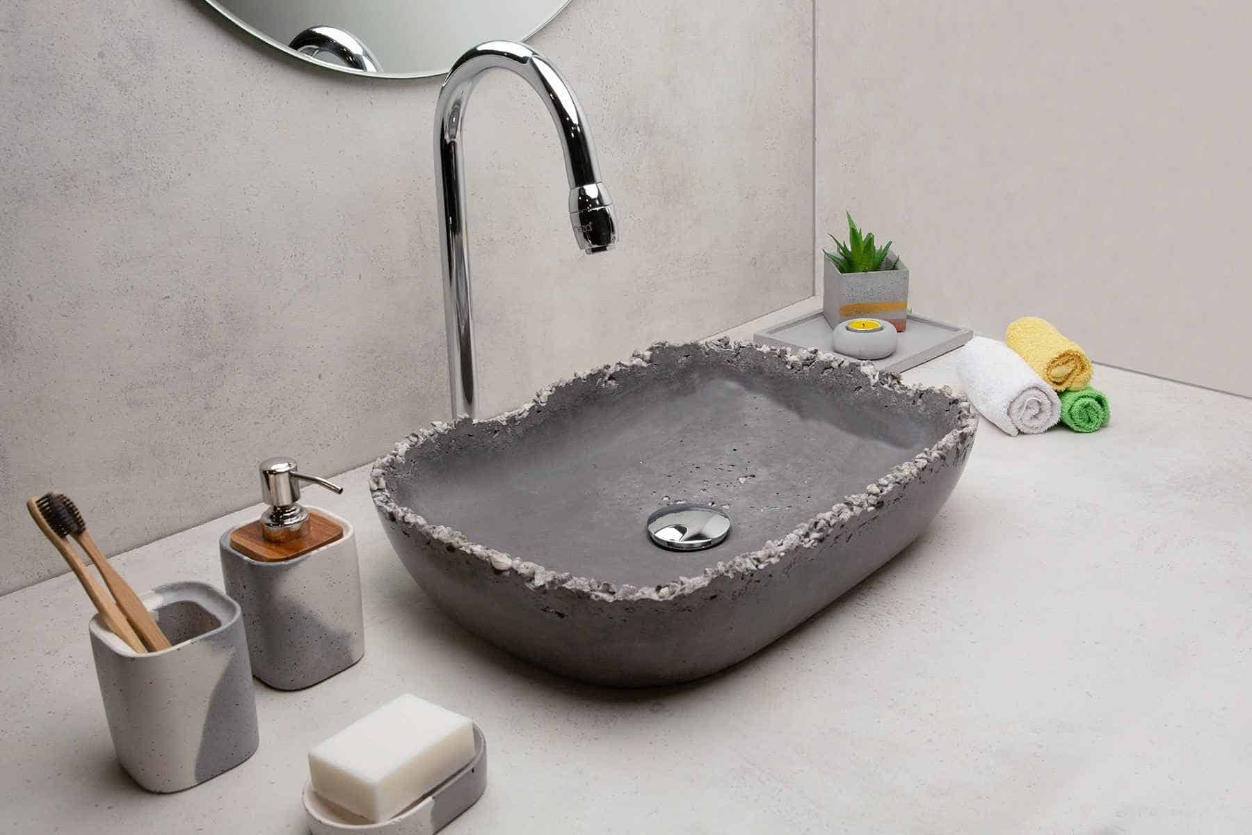 grey stone sink with a tap, multicolor towels and other accessories